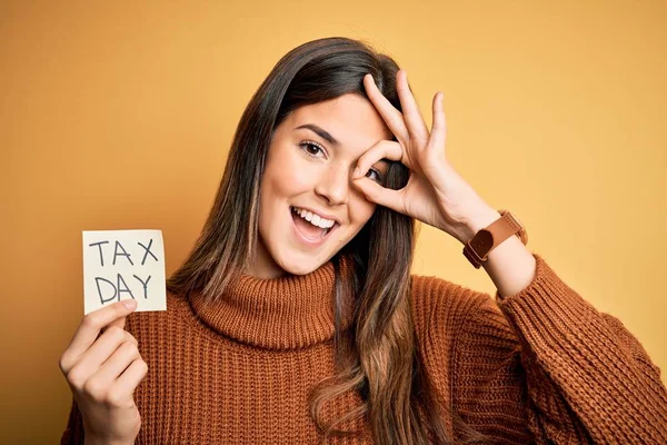 Junges Schönes Mädchen Hält Mahnzettel Mit Steuertagsmeldung Über Gelbem Hintergrund — Stockfoto