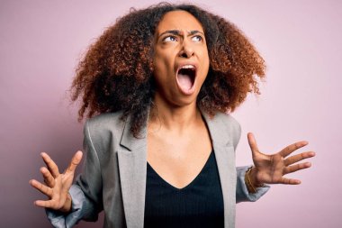 Afro saçlı, şık ceketli, deli gibi bağıran, agresif ifade ve kollarıyla bağıran Afro Amerikalı genç bir iş kadını. Hayal kırıklığı konsepti.