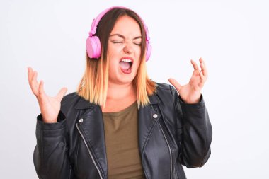Müzik dinleyen genç, güzel bir kadın, izole edilmiş beyaz arka planda kulaklık takarak kollarını kaldırıp heyecanla haykırarak başarının çılgınlığını kutluyor. Kazanan konsept