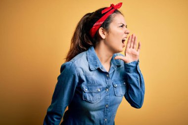 Genç, güzel esmer kadın, günlük kot gömlek ve saç mendili giyip el ele tutuşarak bağırıyor ve bağırıyordu. İletişim konsepti.