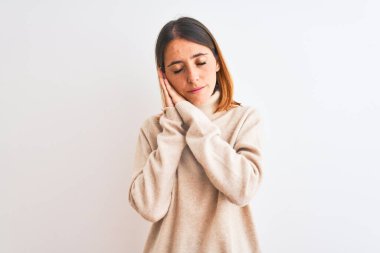 Güzel kızıl saçlı kadın, izole edilmiş arka planda balıkçı yaka kazak giyip uyur, yorgun düşler kurar ve elleri ile birlikte poz verir, gözleri kapalı gülümserdi..