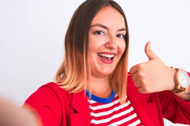 Güzel bir kadın çizgili t-shirt ve ceket giyiyor. İzole edilmiş beyaz arka plan üzerinde duruyor. Kocaman gülümsüyor.