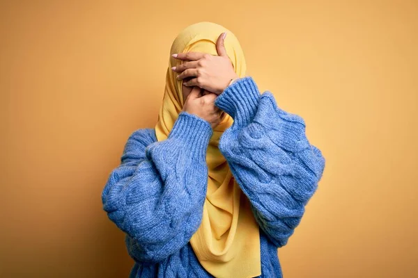 年轻美丽的黑发穆斯林女子 头戴阿拉伯头巾 头戴黄褐色的背景 双手捂住眼睛和嘴 感到惊讶和震惊 隐藏感情 — 图库照片