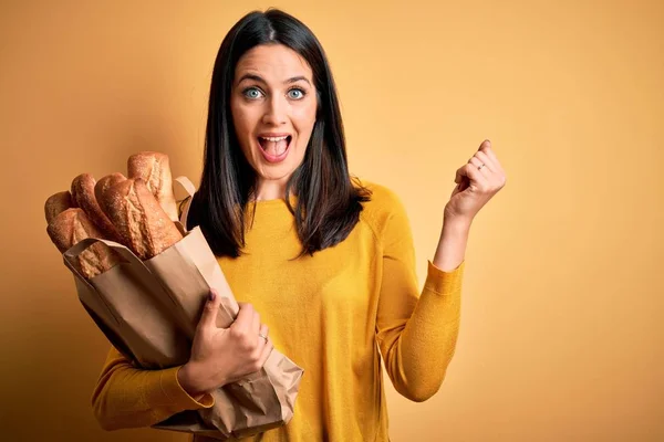 Young Woman Blue Eyes Holding Paper Bag Bread Isolated Yellow — Stock Photo, Image