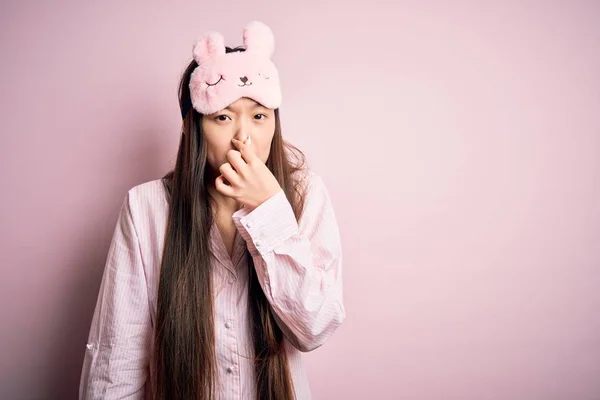 Jonge Aziatische Vrouw Draagt Pyjama Slaapmasker Roze Geïsoleerde Achtergrond Ruiken — Stockfoto