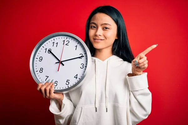 Junge Schöne Chinesin Mit Großer Uhr Vor Isoliertem Rotem Hintergrund — Stockfoto