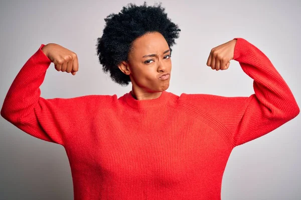 赤のカジュアルなセーターを着て 腕の筋肉を誇りに笑顔を示す巻き毛を持つ若い美しいアフリカ系アメリカ人アフロ女性 フィットネスコンセプト — ストック写真