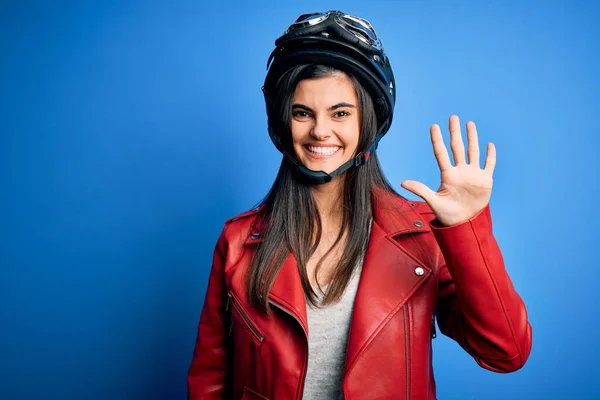 若い美しいブルネットのオートバイのヘルメットとジャケットを身に着けている女性が表示され 指番号5で指摘しながら 自信と幸せ笑みを浮かべて — ストック写真