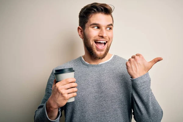 若いですブロンド男とともに髭と青い目飲みカップのコーヒー白い背景ポインティングとショーとともに親指で側まで幸せな顔笑顔 — ストック写真