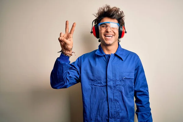 Joven Constructor Con Uniforme Orejeras Sobre Fondo Blanco Aislado Sonriendo — Foto de Stock