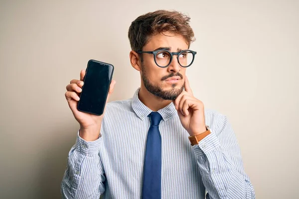 Jovem Empresário Segurando Smartphone Sobre Fundo Branco Isolado Rosto Sério — Fotografia de Stock