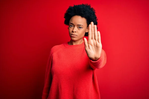 手の手のひらで歌うのをやめるカジュアルなセーターを着て巻き毛を持つ若い美しいアフリカ系アメリカ人アフロ女性 顔に負と深刻なジェスチャーで警告式 — ストック写真