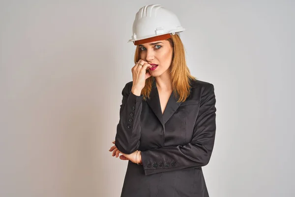 Rudowłosa Biała Bizneswoman Kasku Ochronnym Wyglądająca Zestresowaną Zdenerwowaną Rękami Obgryzającymi — Zdjęcie stockowe