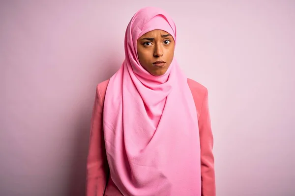 孤立したピンクの背景にイスラム教徒のヒジャーブを身に着けている若いアフリカ系アメリカ人アフリカ人女性は懐疑的で緊張しており 問題のために動揺している 負の人 — ストック写真