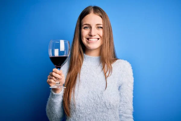 Joven Hermosa Pelirroja Bebiendo Copa Vino Tinto Sobre Fondo Azul —  Fotos de Stock