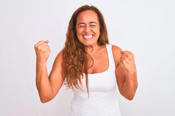 白人の孤立した背景の上に立つ中年の成熟した女性は非常に満足し 腕を上げて勝者のジェスチャーを行う興奮し 笑顔と成功のために叫んでいます お祝いのコンセプト — ストック写真