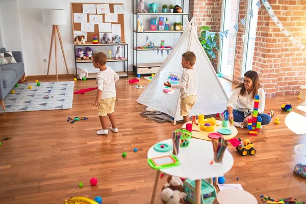 Schöne Lehrerin Und Kleinkinder Spielen Kindergarten Mit Viel Spielzeug — Stockfoto