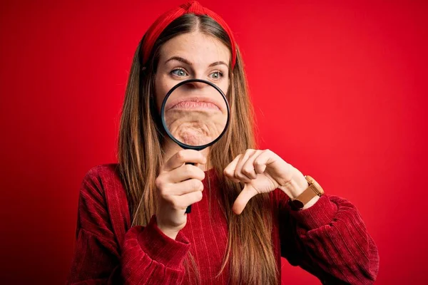 Ung Vacker Rödhårig Detektiv Kvinna Med Förstoringsglas Över Isolerad Röd — Stockfoto