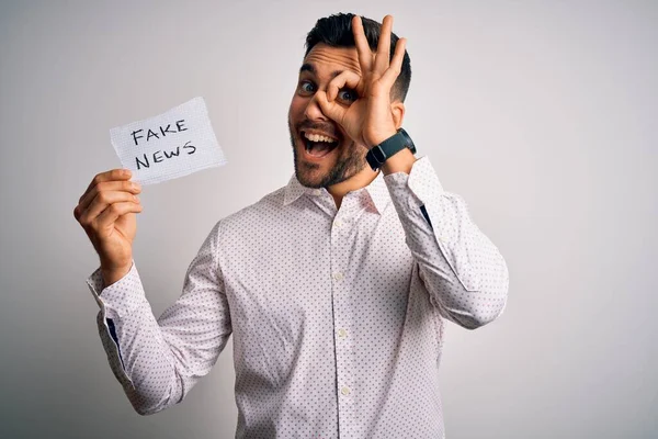 Joven Hombre Negocios Sosteniendo Papel Noticias Falsas Sobre Fondo Aislado — Foto de Stock