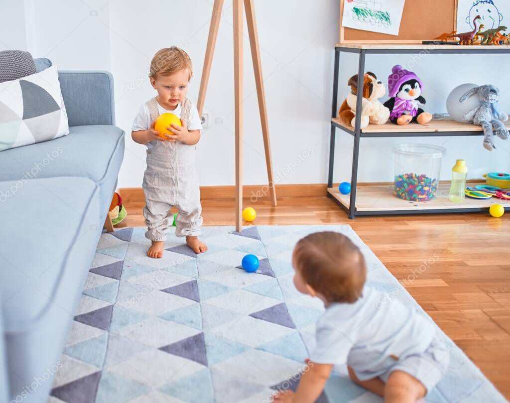 Beautiful toddlers playing around lots of toys at kindergarten