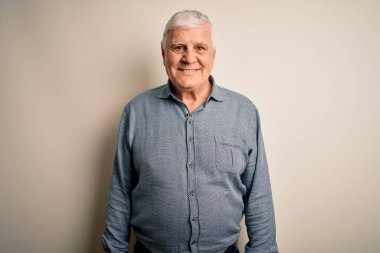 Üst düzey yakışıklı beyaz gömlekli adam izole edilmiş beyaz arka planda mutlu ve havalı bir gülümsemeyle dikiliyor. Şanslı kişi..