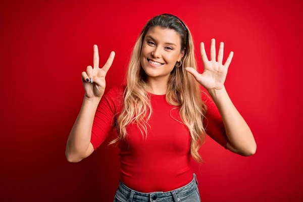 Jovem Mulher Loira Bonita Vestindo Camiseta Casual Sobre Fundo Vermelho — Fotografia de Stock