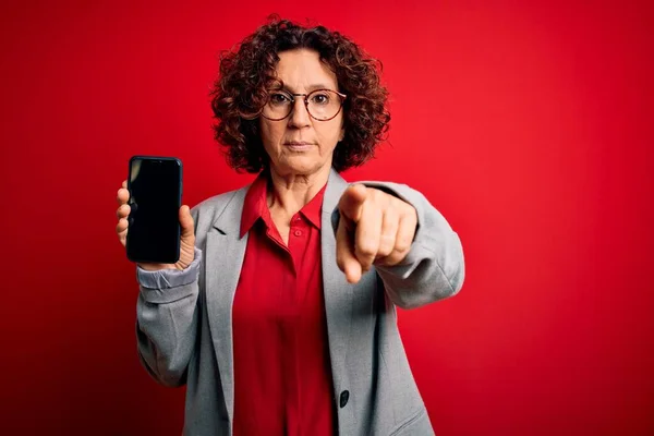 Średniowieczne Kręcone Kobieta Trzyma Smartfon Pokazując Ekran Izolowanym Czerwonym Tle — Zdjęcie stockowe