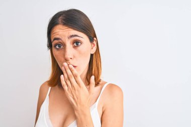 Beautiful redhead woman wearing casual white t-shirt over isolated background cover mouth with hand shocked with shame for mistake, expression of fear, scared in silence, secret concept