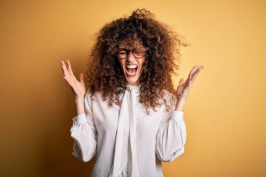 Kıvırcık saçlı ve piercingli genç ve güzel bir kadın. Gömlek ve gözlük takıyor. Başarı için çılgınca kutlama yapıyor. Kazanan konsept