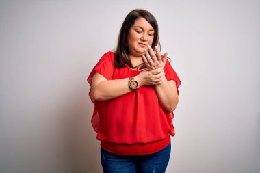 Güzel esmer, iri yarı bir kadın izole edilmiş beyaz arka planda günlük kırmızı tişört giyiyor. Ellerinde ve parmaklarında ağrı, iltihaplanma.