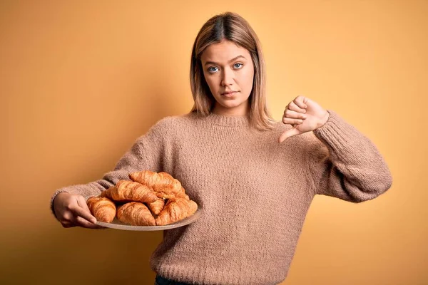 Young Beautiful Woman Holding Plate Croissants Isolated Yellow Background Angry — Stock Photo, Image