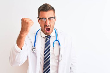 Steteskop takan genç yakışıklı doktor öfkeli ve kızgın bir şekilde öfkeyle bağırırken yumruk kaldırıyor. Öfke ve agresif kavram.