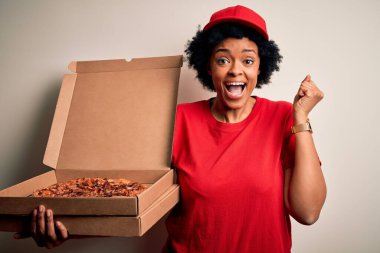 Genç Afro-Amerikalı, kıvırcık saçlı, elinde pizza kutusu olan, gururla bağıran, zaferi ve başarıyı kutlayan heyecanlı, neşeli bir afro kadın.