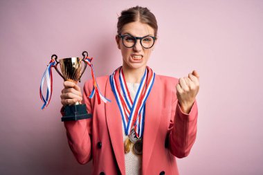 Pembe arka planda madalyalar takan genç, güzel, kızıl saçlı bir kadın. Sinirli ve sinirli bir şekilde bağırıyor. Öfkeyle bağırıyor.