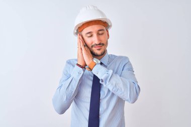 Müteahhit kaskı takan genç bir iş adamı izole edilmiş arka planda uyur, yorgun düşler kurar, el ele poz verir ve gözleri kapalı gülümserdi..