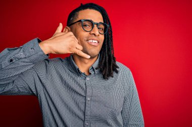 Rastgele gömlek ve gözlüklerle gülümseyen, el ve parmaklarıyla telefonla konuşan Afro-Amerikan genç adam. İletişim kavramları.