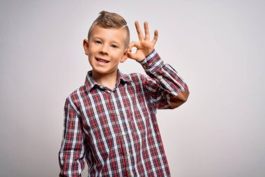 Mavi gözlü, zarif tişörtlü, izole edilmiş arka planda duran, gülümseyen, el ve parmaklarıyla 