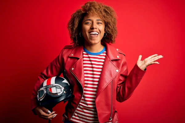 Joven Mujer Motociclista Afroamericana Sosteniendo Casco Motocicleta Sobre Fondo Rojo —  Fotos de Stock