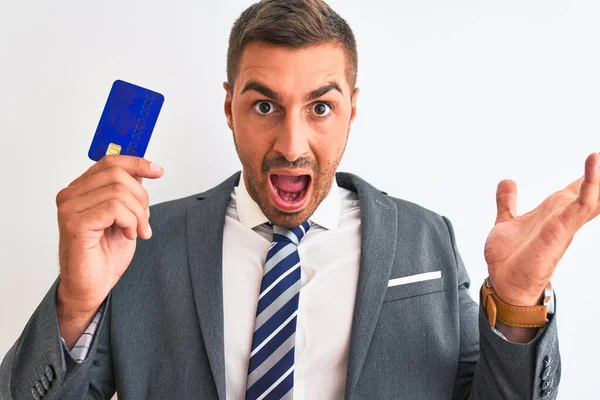 Joven Hombre Negocios Guapo Sosteniendo Tarjeta Crédito Sobre Fondo Aislado —  Fotos de Stock