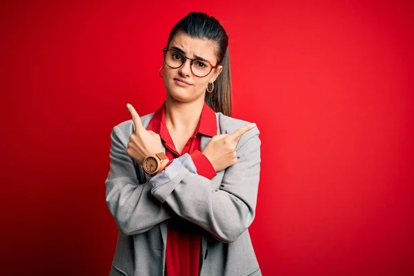 Mladá Krásná Brunetka Podnikatelka Bundě Brýlích Červeném Pozadí Ukazuje Obě — Stock fotografie