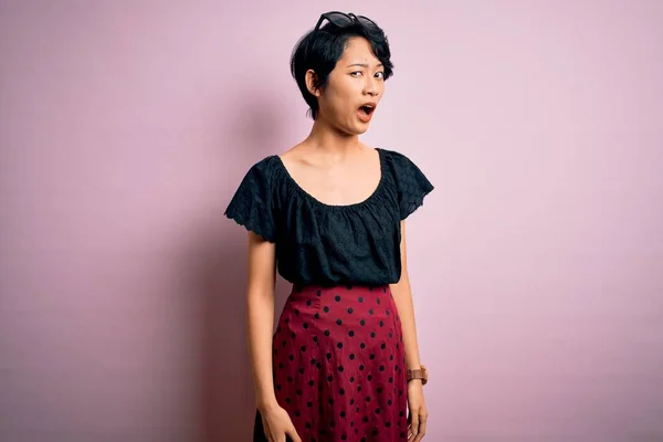 캐주얼 드레스 아리따운 아시아 소녀는 분홍색 위에서 회의적 빈정대며 벌리고 — 스톡 사진
