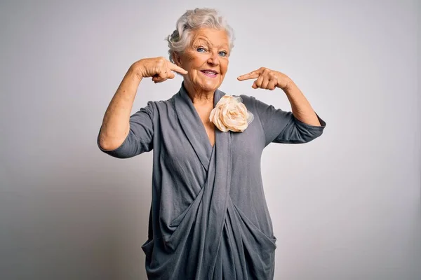 Senior beautiful grey-haired woman wearing casual dress standing over white background smiling cheerful showing and pointing with fingers teeth and mouth. Dental health concept.