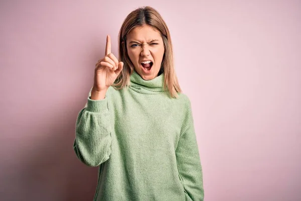 年轻美丽的金发女人穿着冬季羊毛衫 背景粉色孤立 手指指向与成功的想法 又兴奋又快乐 第一部分 — 图库照片