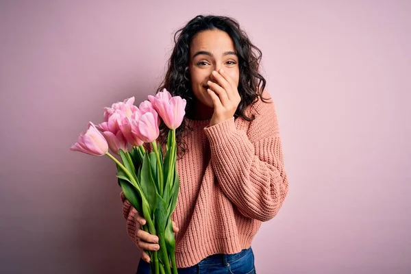 若いです美しいですロマンチックな女性とともに巻き毛保持花束のピンクチューリップ笑いと恥ずかしいクスクスカバー口とともに手 ゴシップとスキャンダルコンセプト — ストック写真