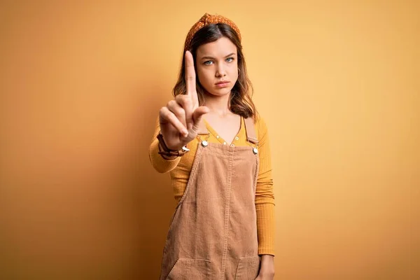Sarı Arka Plan Üzerinde Duran Genç Güzel Sarışın Kız Parmağını — Stok fotoğraf