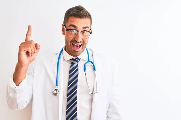Młody Przystojny Lekarz Noszący Stetoskop Odosobnionym Tle Wskazujący Palcem Udany — Zdjęcie stockowe