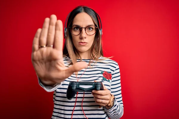 Fiatal Szőke Játékos Segítségével Gamepad Videojátékok Piros Háttér Nyitott Kézzel — Stock Fotó