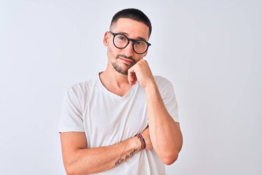 Gözlük takan ve izole edilmiş arka planda duran yakışıklı genç adam çapraz kollu depresyon sorunlarından yorgun ve sıkılmış göründüğünü düşünüyor..