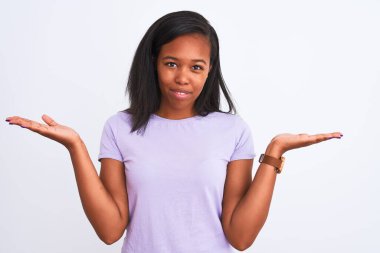 Güzel genç Afro-Amerikan kadın izole arka plan clueless ve şaşkın bir ifadeyle kollar ve eller kaldırdı. Şüphe kavramı.