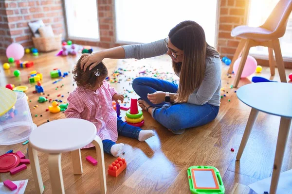 Young Beautiful Teacher Toddler Sitting Floor Building Pyramid Using Hoops — Stock Photo, Image